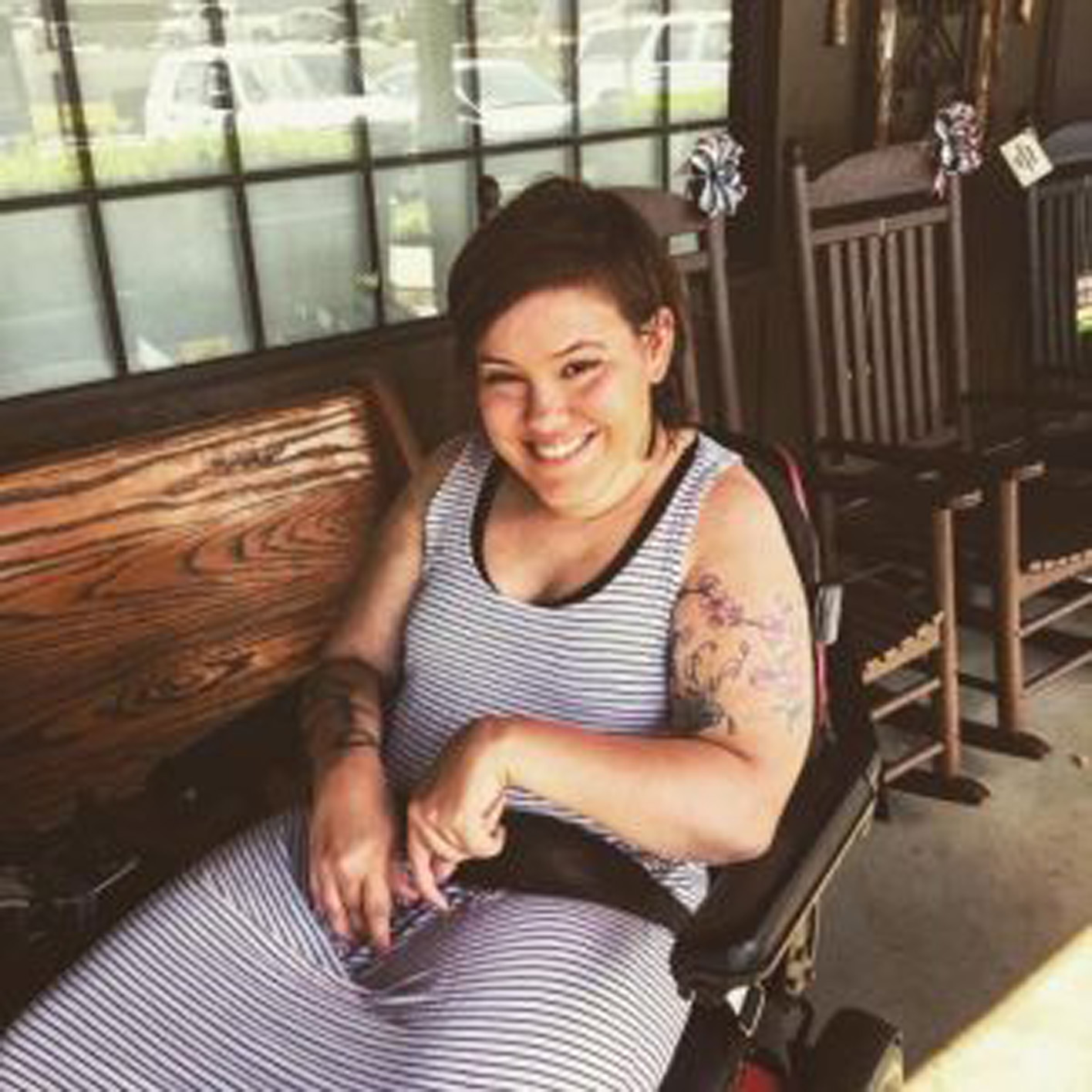 a woman in a power wheelchair smiling