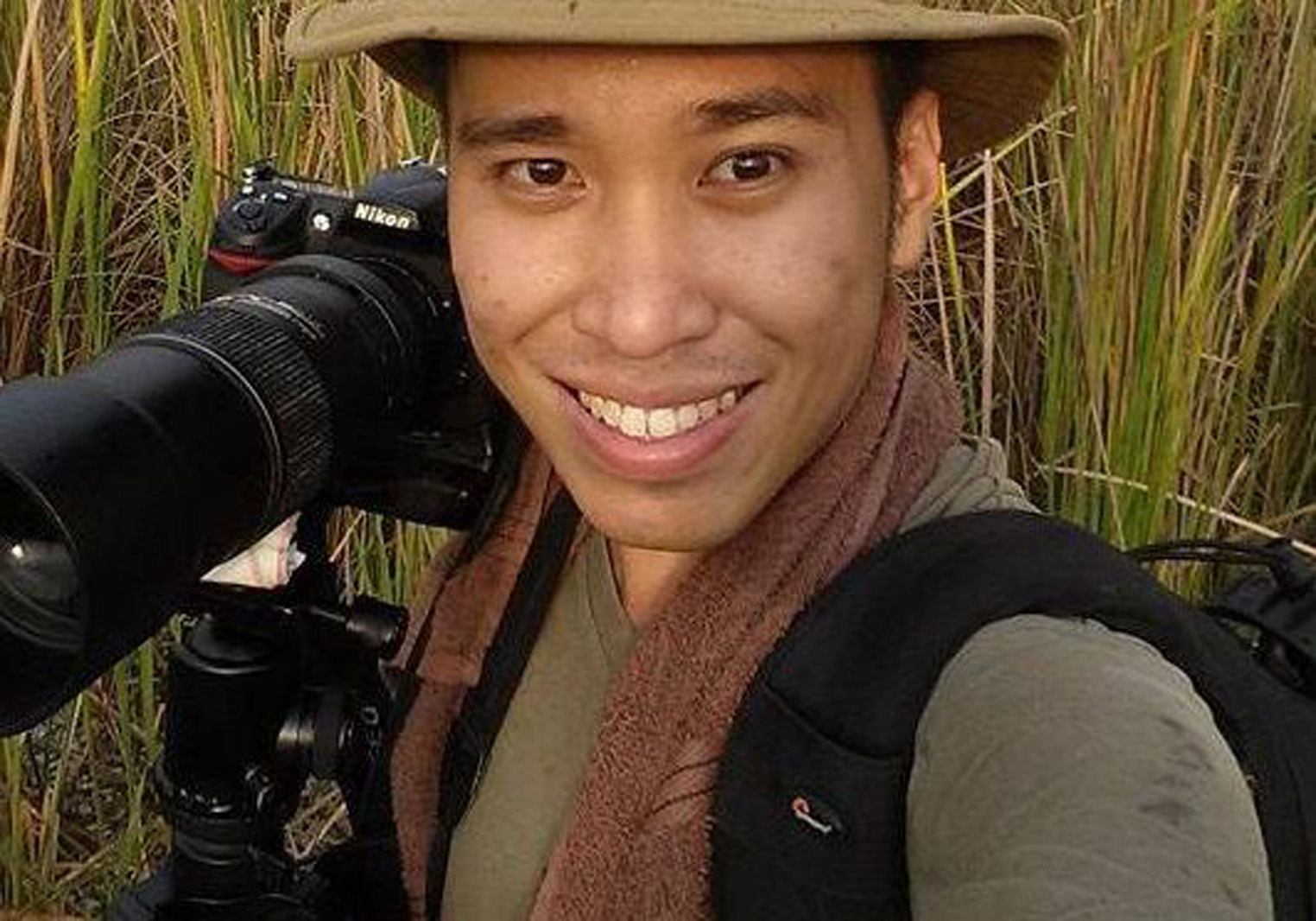 a man smiling with a camera