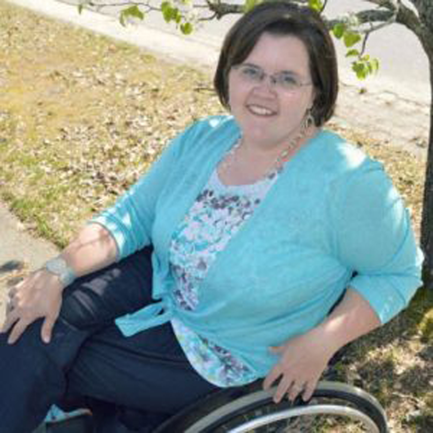 a woman in a manual wheelchair smiling