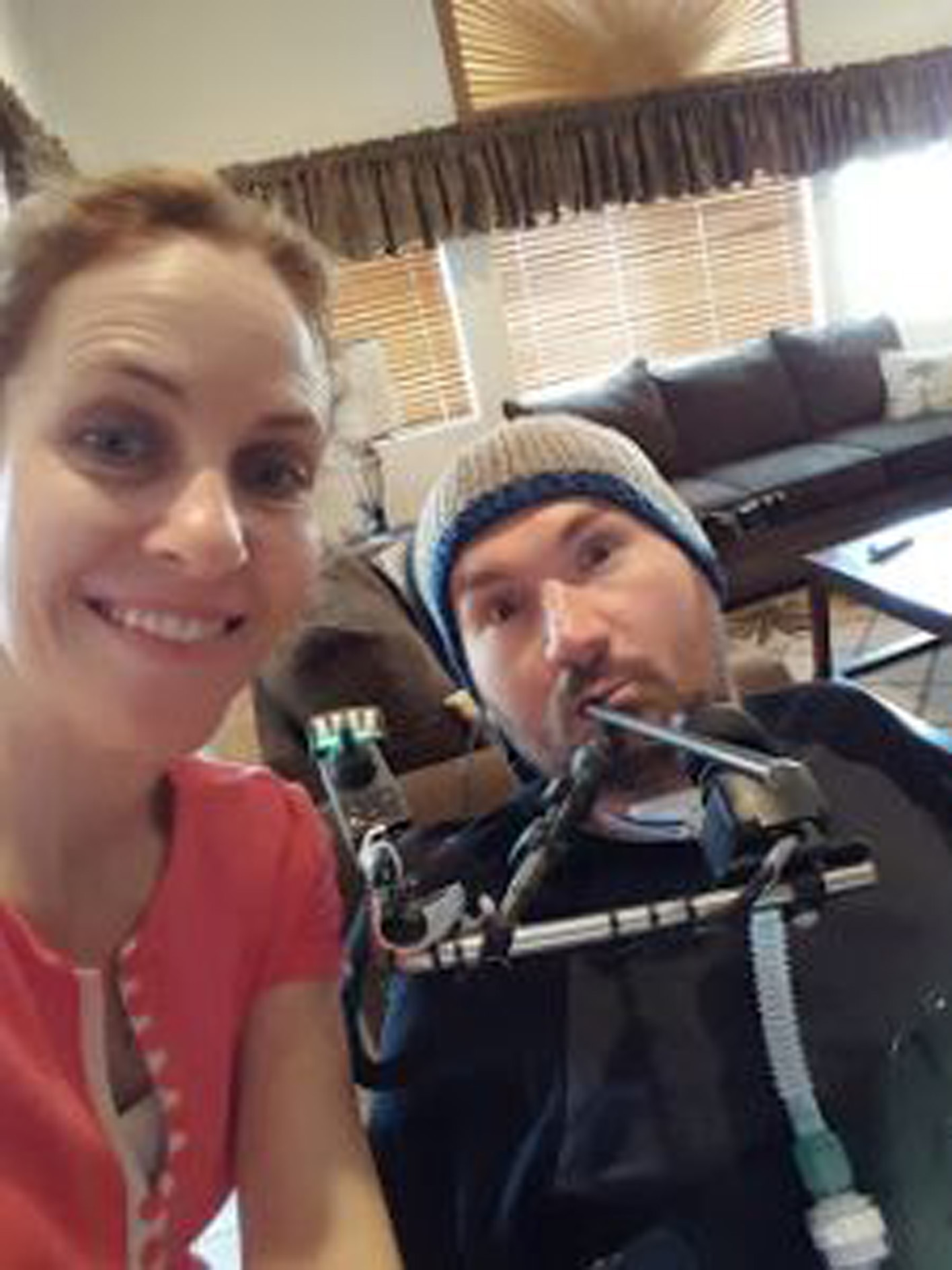 woman stands next to a man in a wheelchair