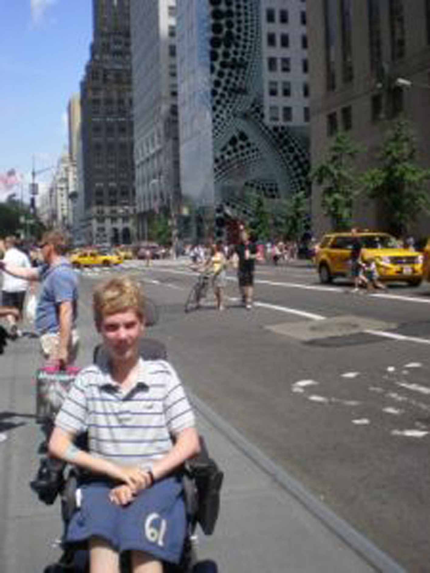 young man with SMA in a power wheelchair on the streets of new york city