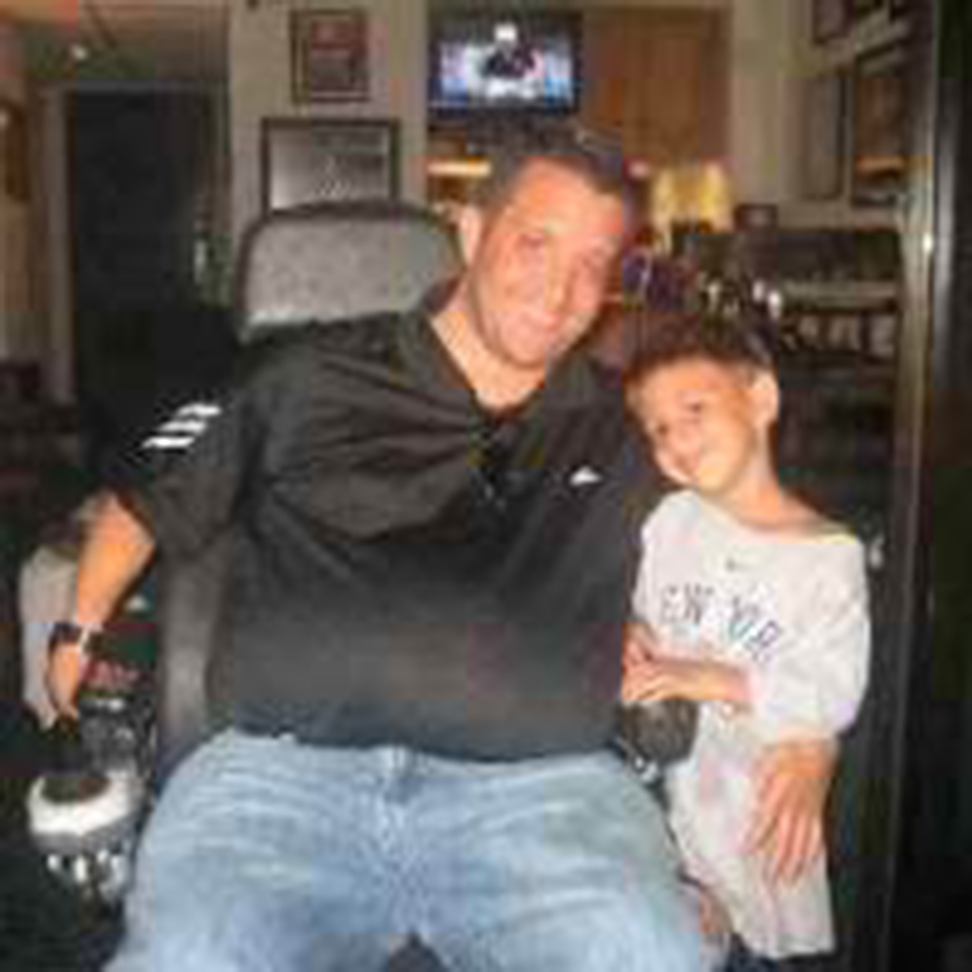 quadriplegic dad in a power wheelchair with his son standing next to him
