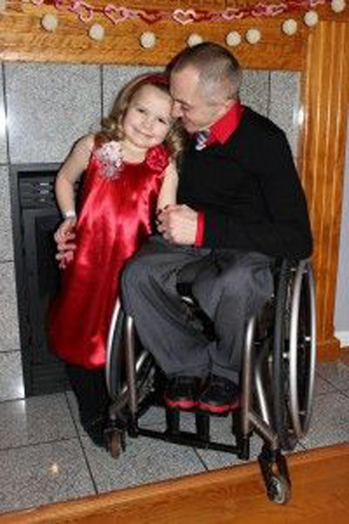 dad with osteogenesis imperfecta in a manual wheelchair and his daughter standing next to him