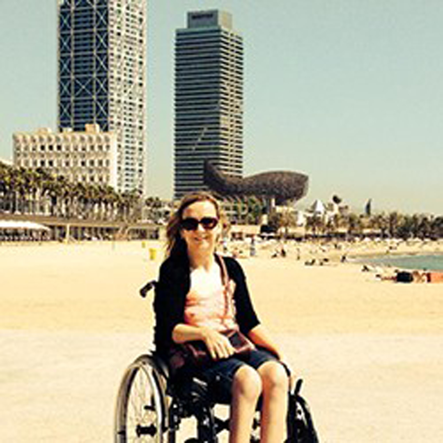 a woman in a manual wheelchair on the beach