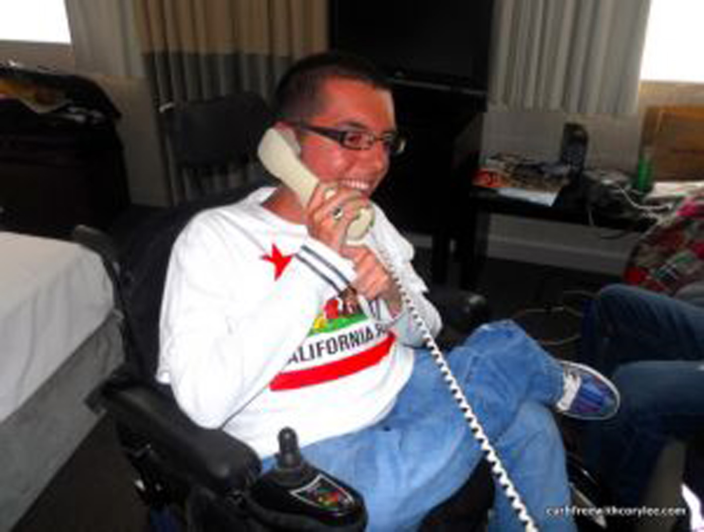 man in a power wheelchair on a telephone
