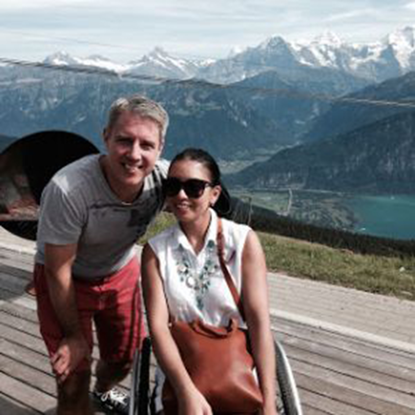 Woman in a wheelchair with a man crouched down next to her