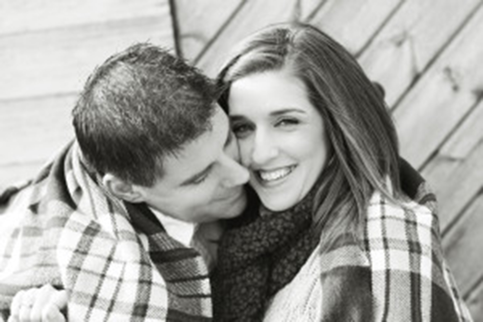 A man and woman snuggling their faces and smiling