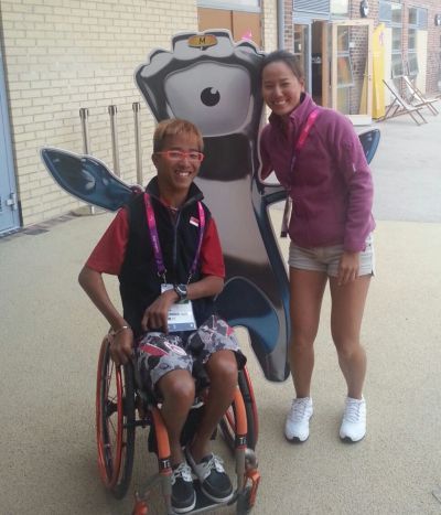 man in a wheelchair next to a woman standing