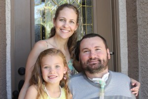 a ventilator dependent quadriplegic man, his wife and their daughter smiling