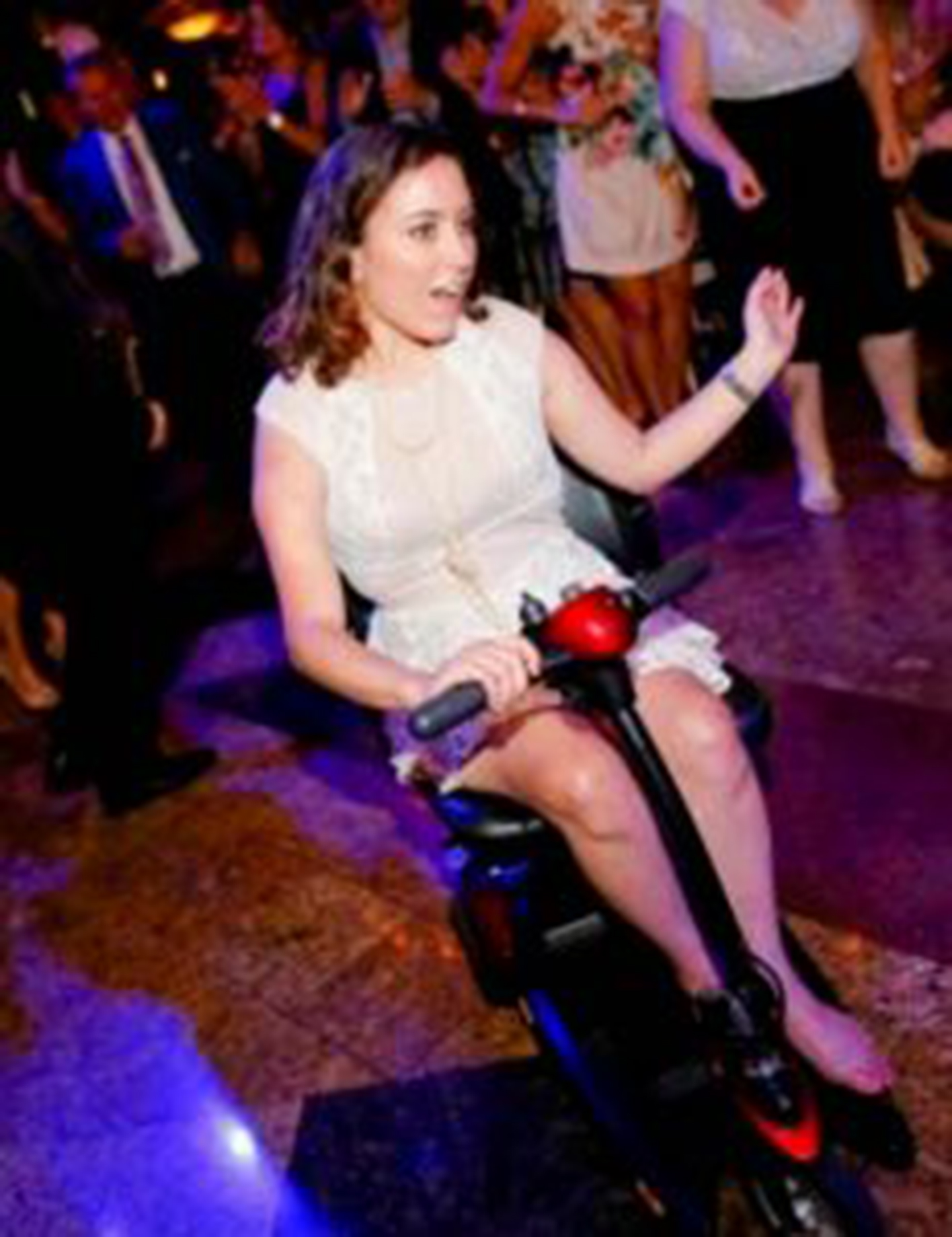 A woman on a scooter on a dance floor dancing
