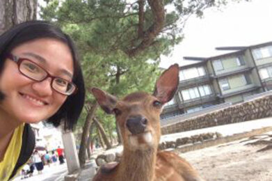 woman smiling in selfie with a deer