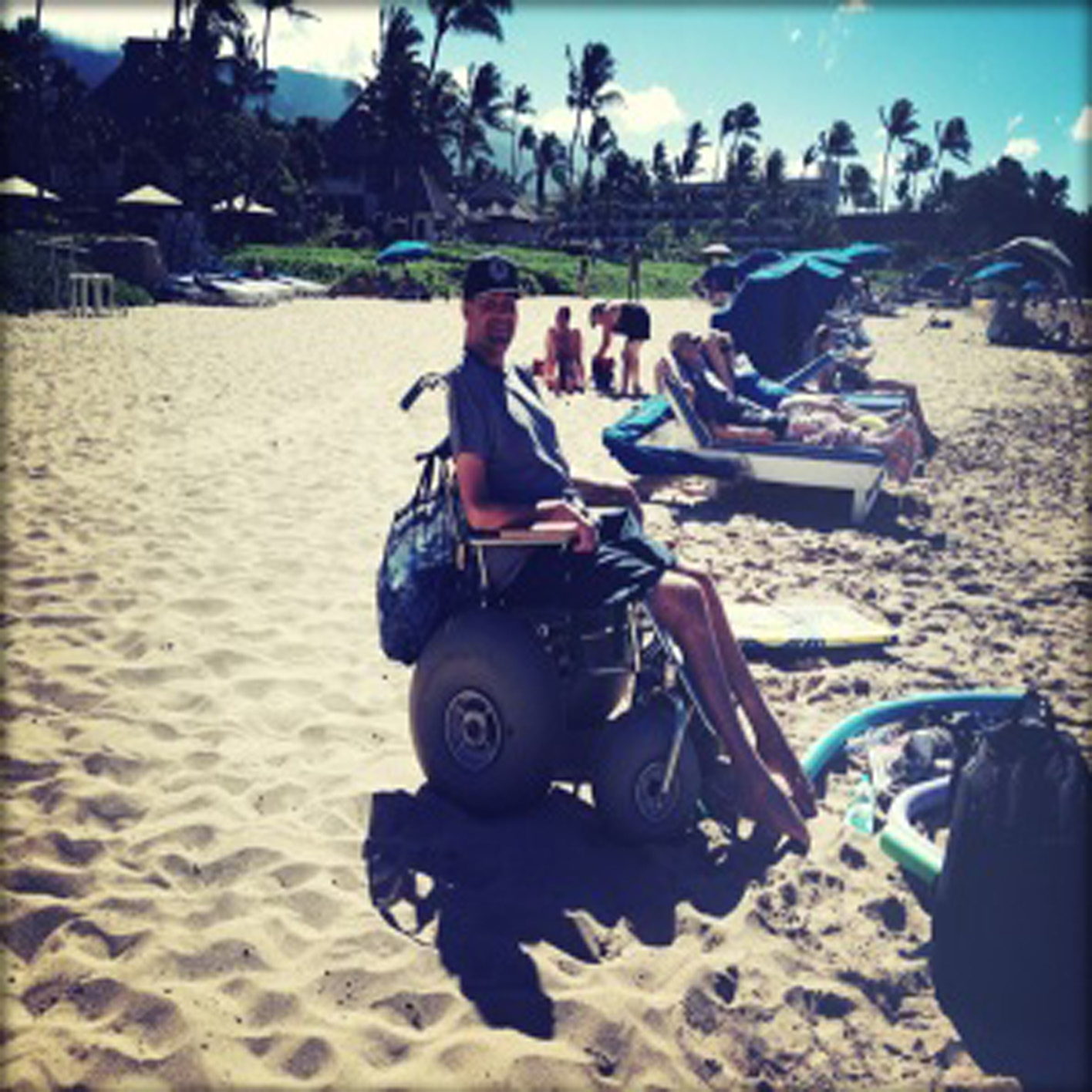 man in adapted beach wheelchair on the beach