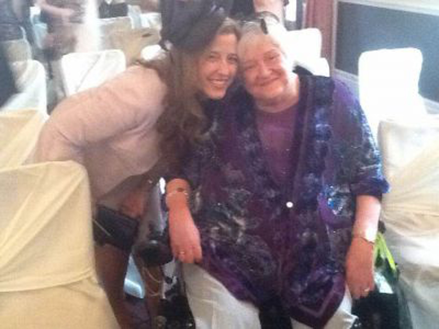 a quadriplegic mom in a wheelchair next to her daughter who is smiling