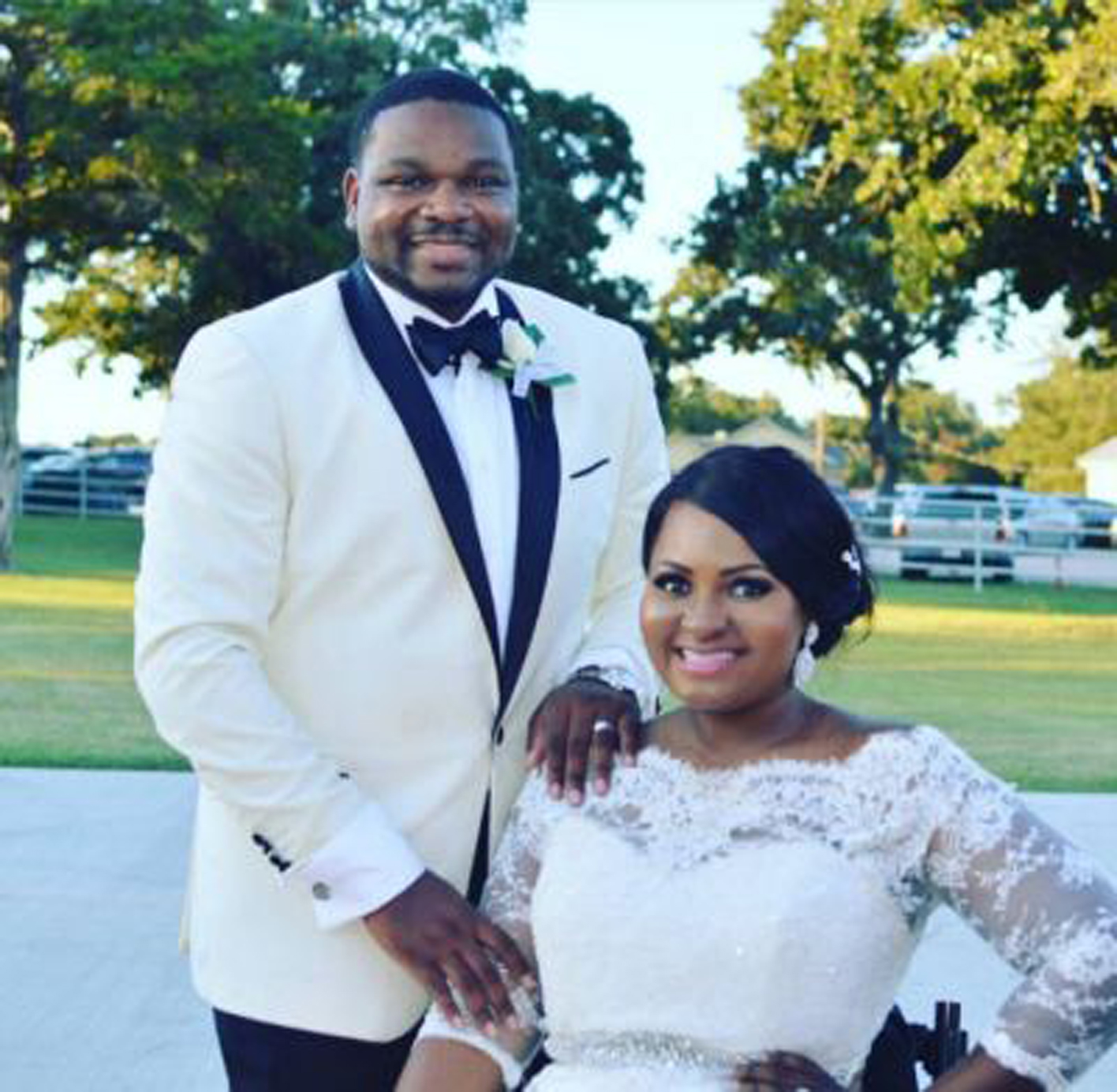 groom standing with his bride in a wheelchair