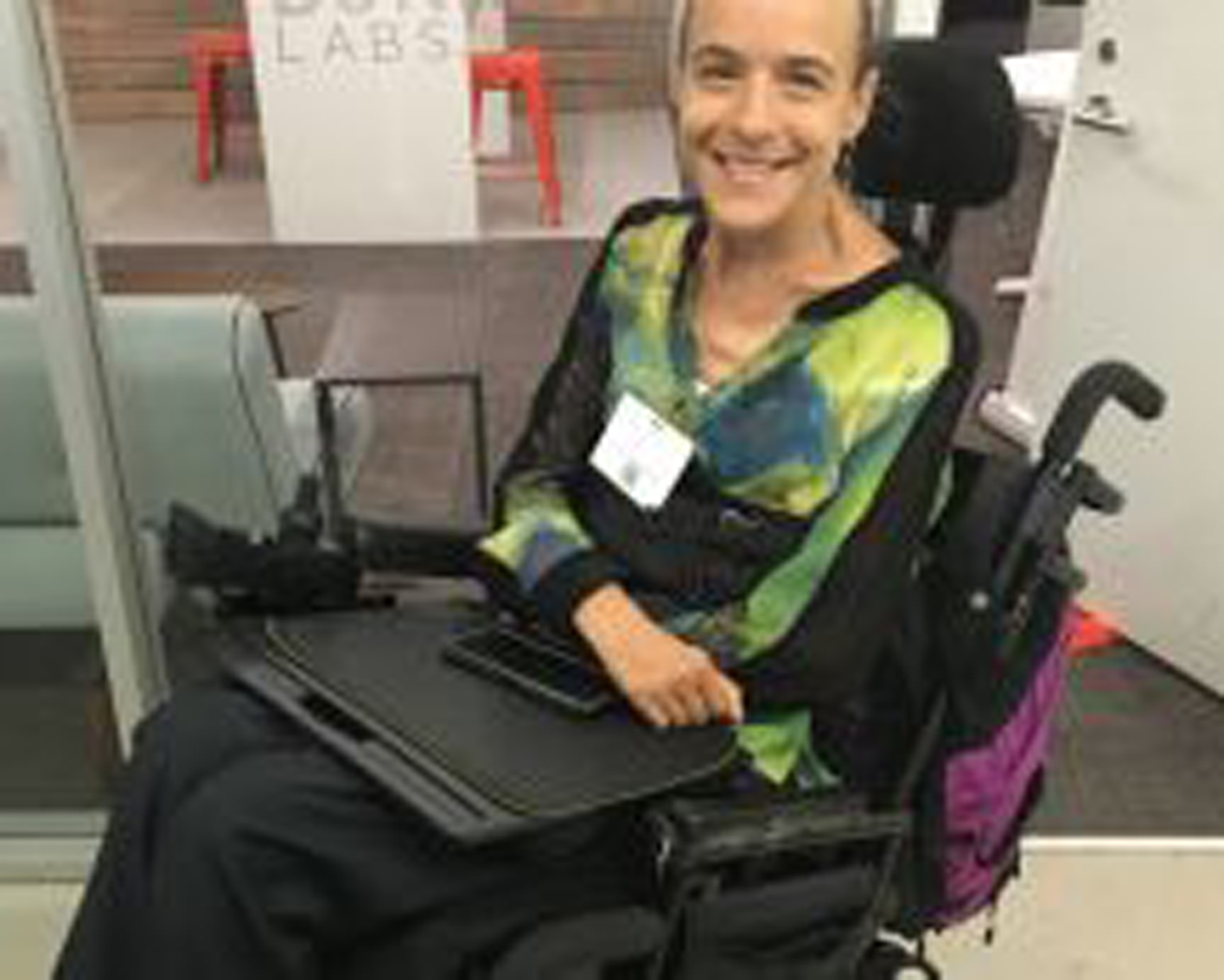 woman in a wheelchair smiles at the camera