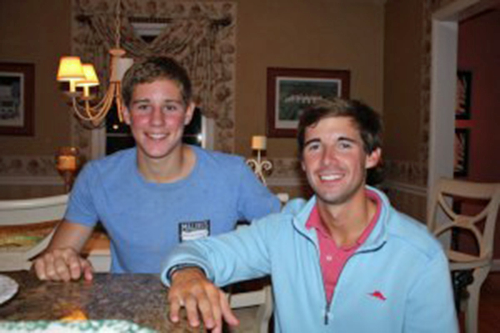 Two young men seated and smiling