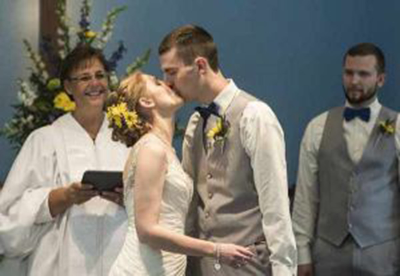 a bride and groom kissing at the altar