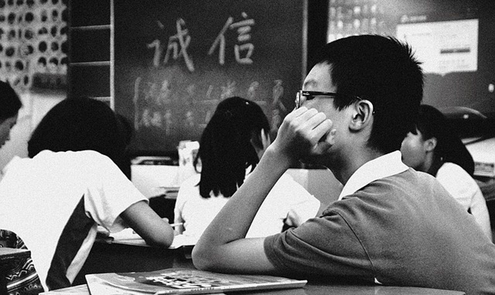 Kid sitting in a classroom with other students