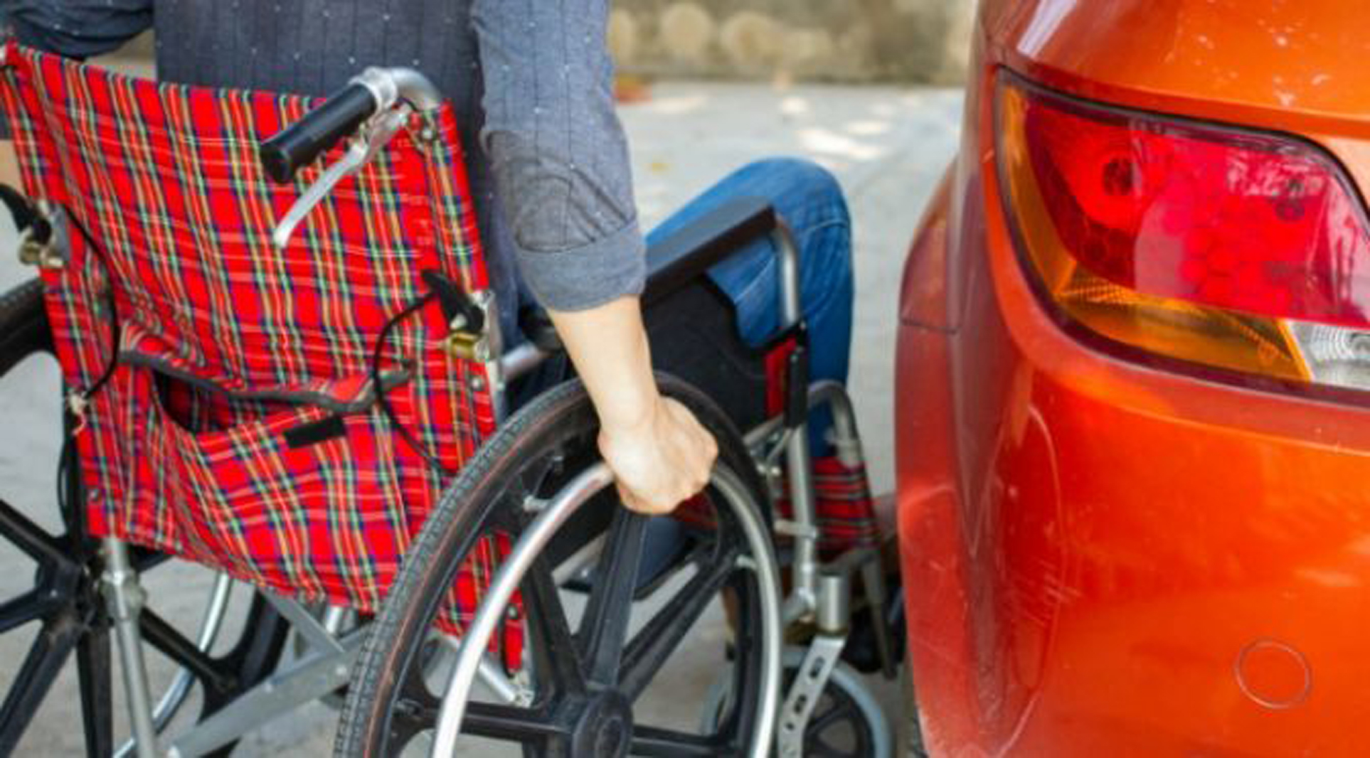 a manual wheelchair pulled up next to a car
