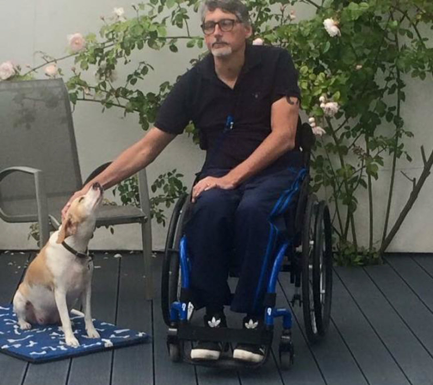 male wheelchair user pets his dog