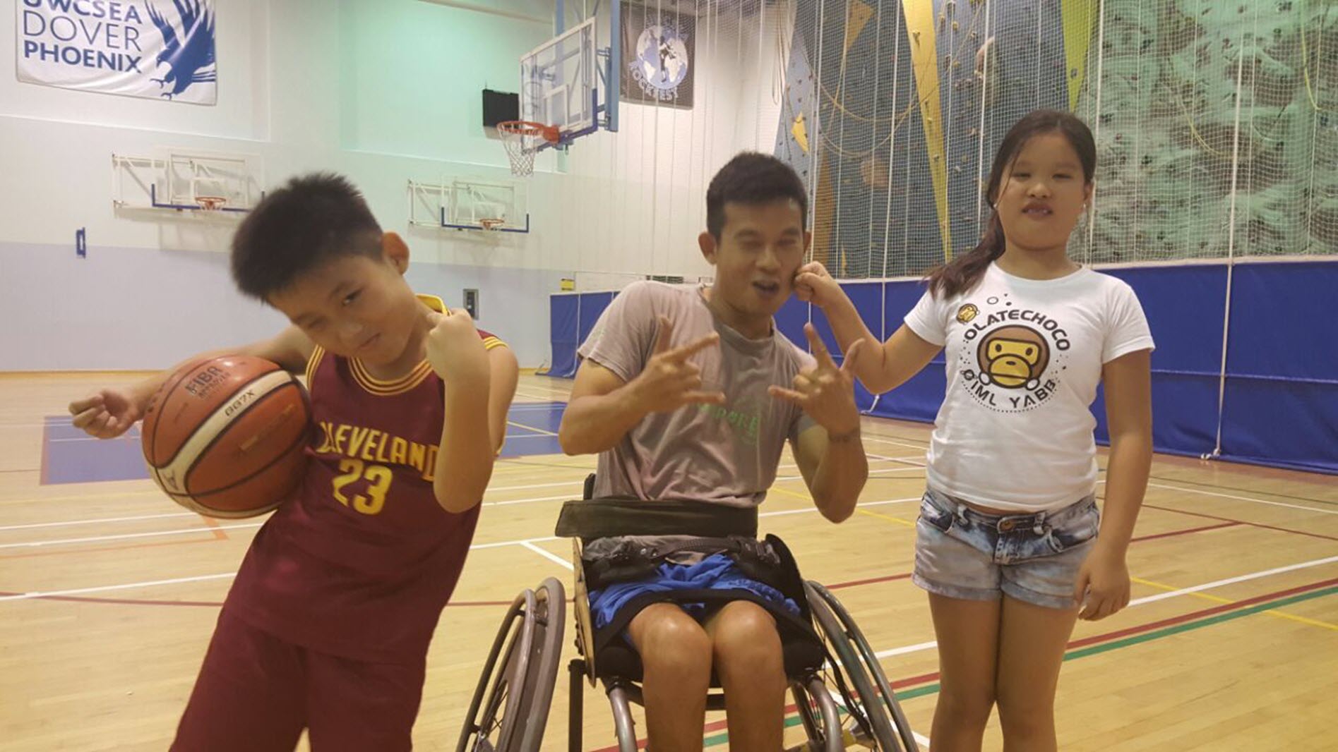 paraplegic basketball player poses with two young children