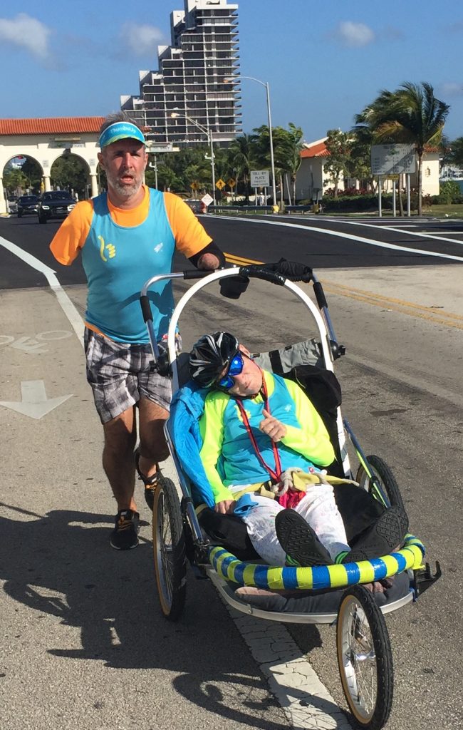 amputee man pushes quadriplegic woman in a buggy