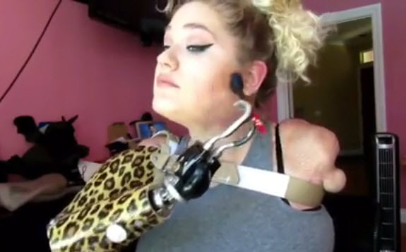 quadruple amputee applies makeup with a prosthesis