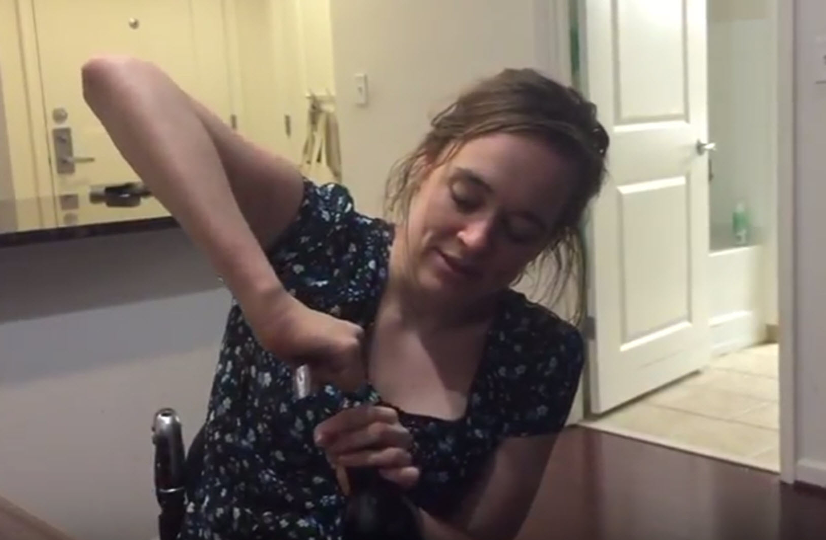 quadriplegic opens a bottle of wine with a manual corkscrew