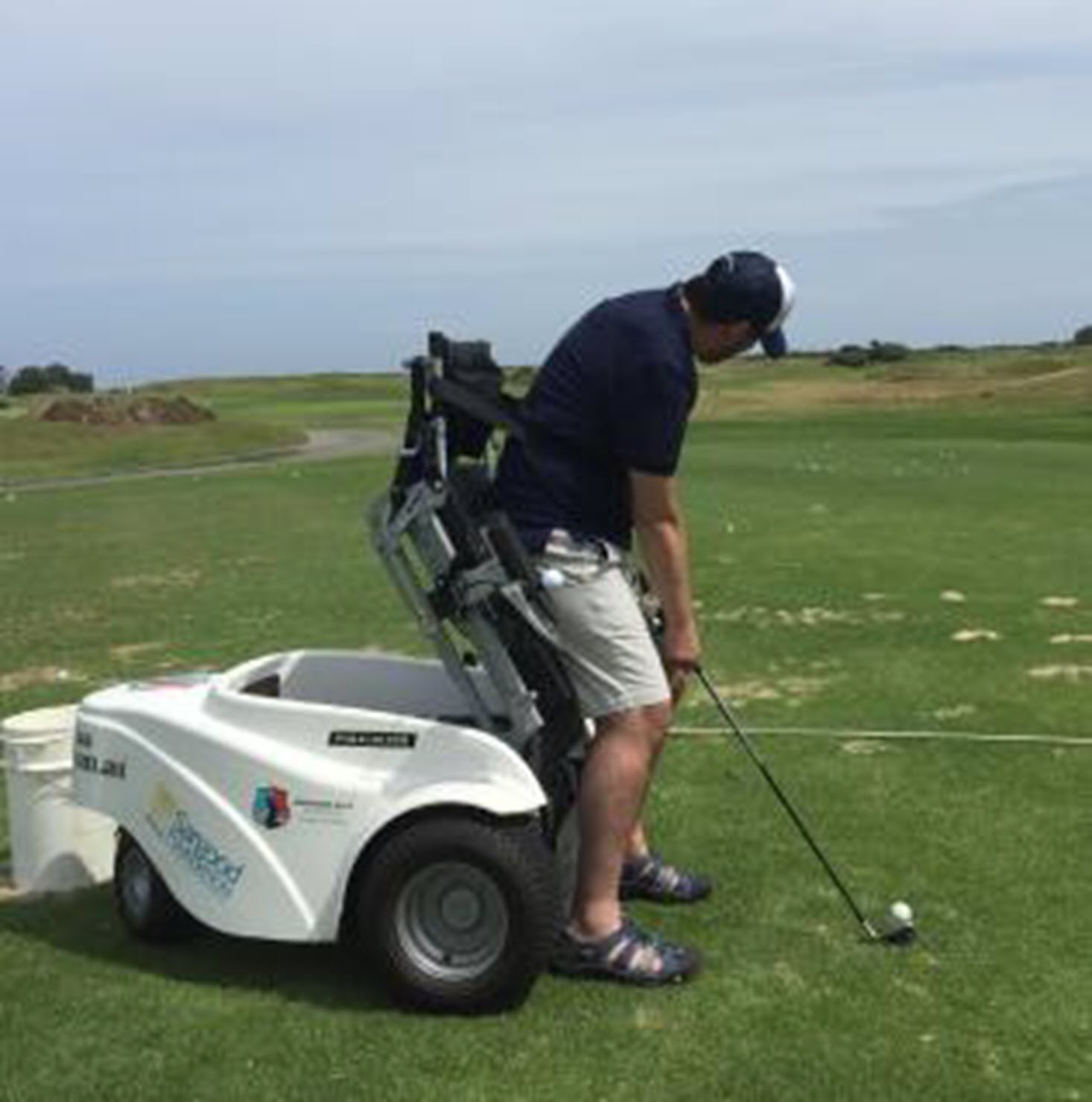 man golfs with the aid of an adapted golf cart