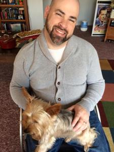 man in a wheelchair holds a dog on his lap