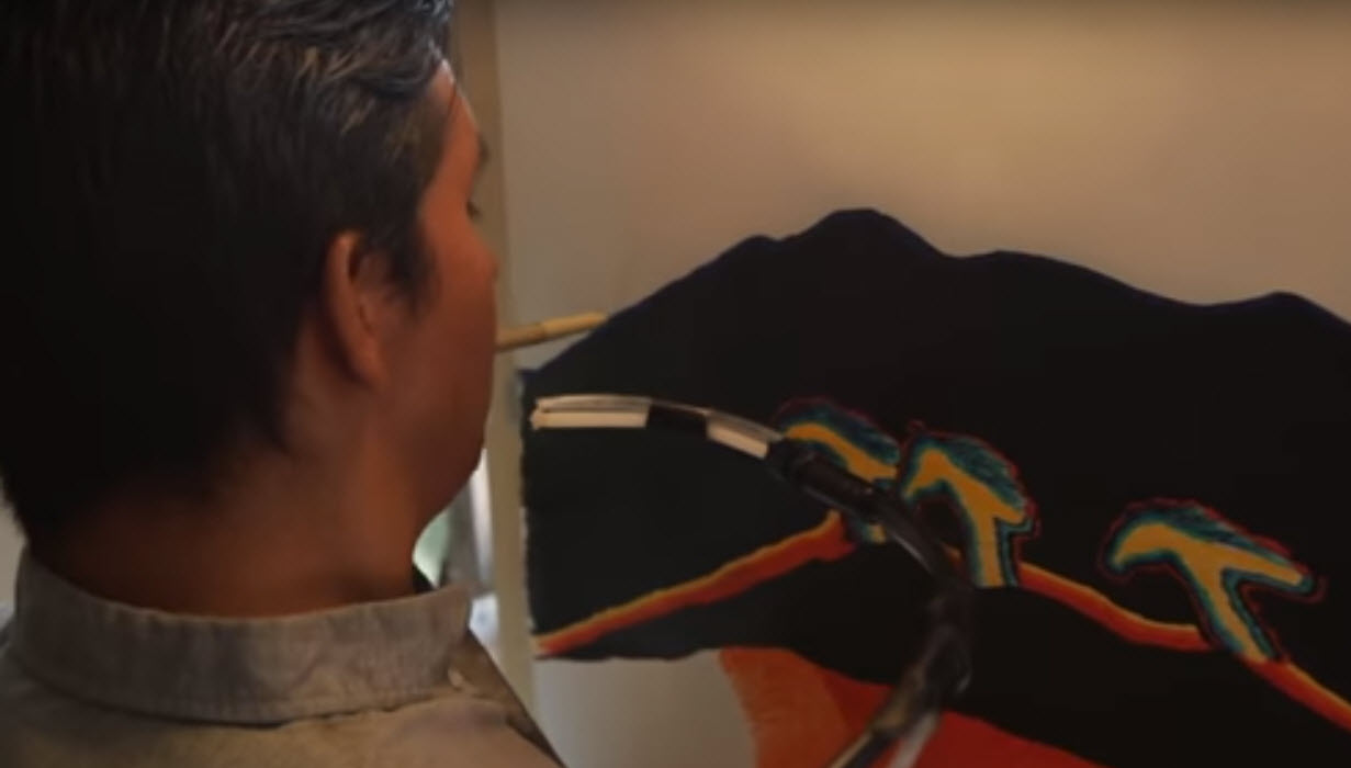 quadriplegic man draws using a pen in his mouth