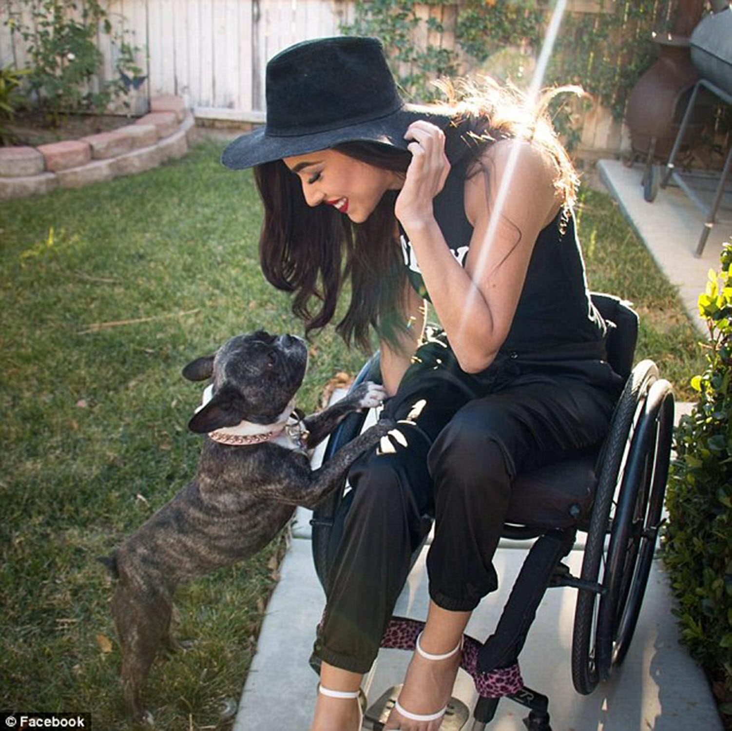 quadriplegic woman smiles and looks down at her dog