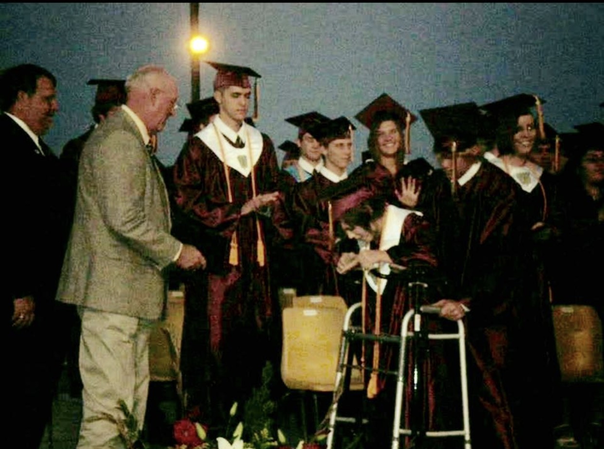 woman with cerebral palsy walks across the stage at graduation