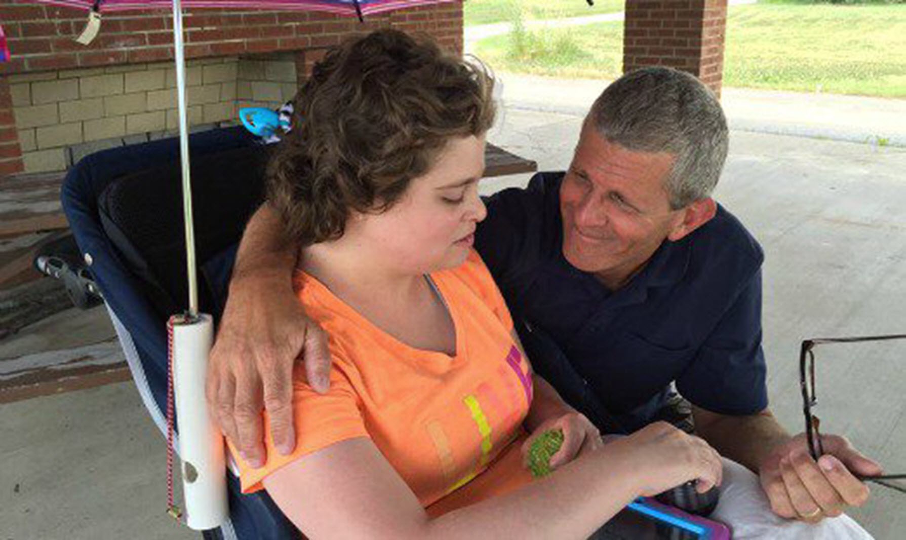 a father puts his arm around his daughter who has an intellectual disability