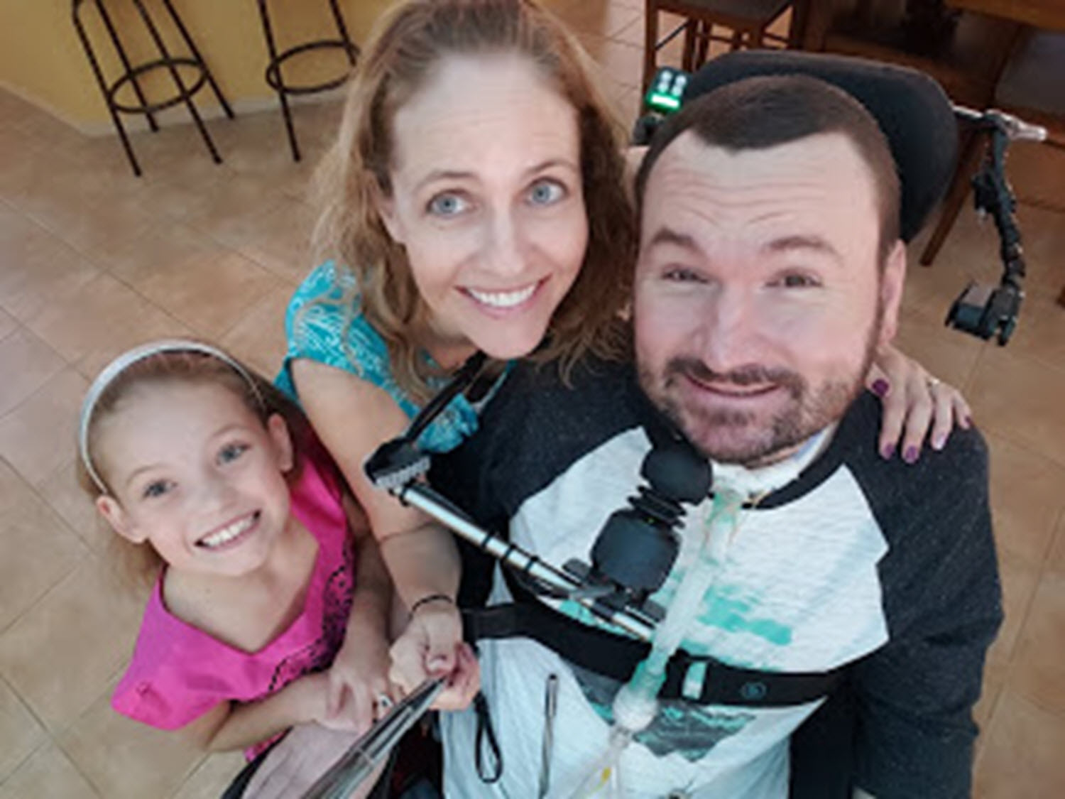 quadriplegic dad poses for a selfie with his wife and daughter