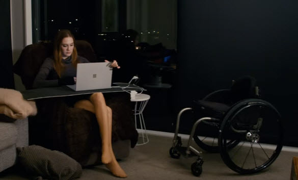 tetraplegic works on her laptop while sitting in a comfy chair
