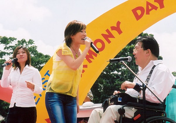 quadriplegic Gilbert Tan sings on stage with musicians