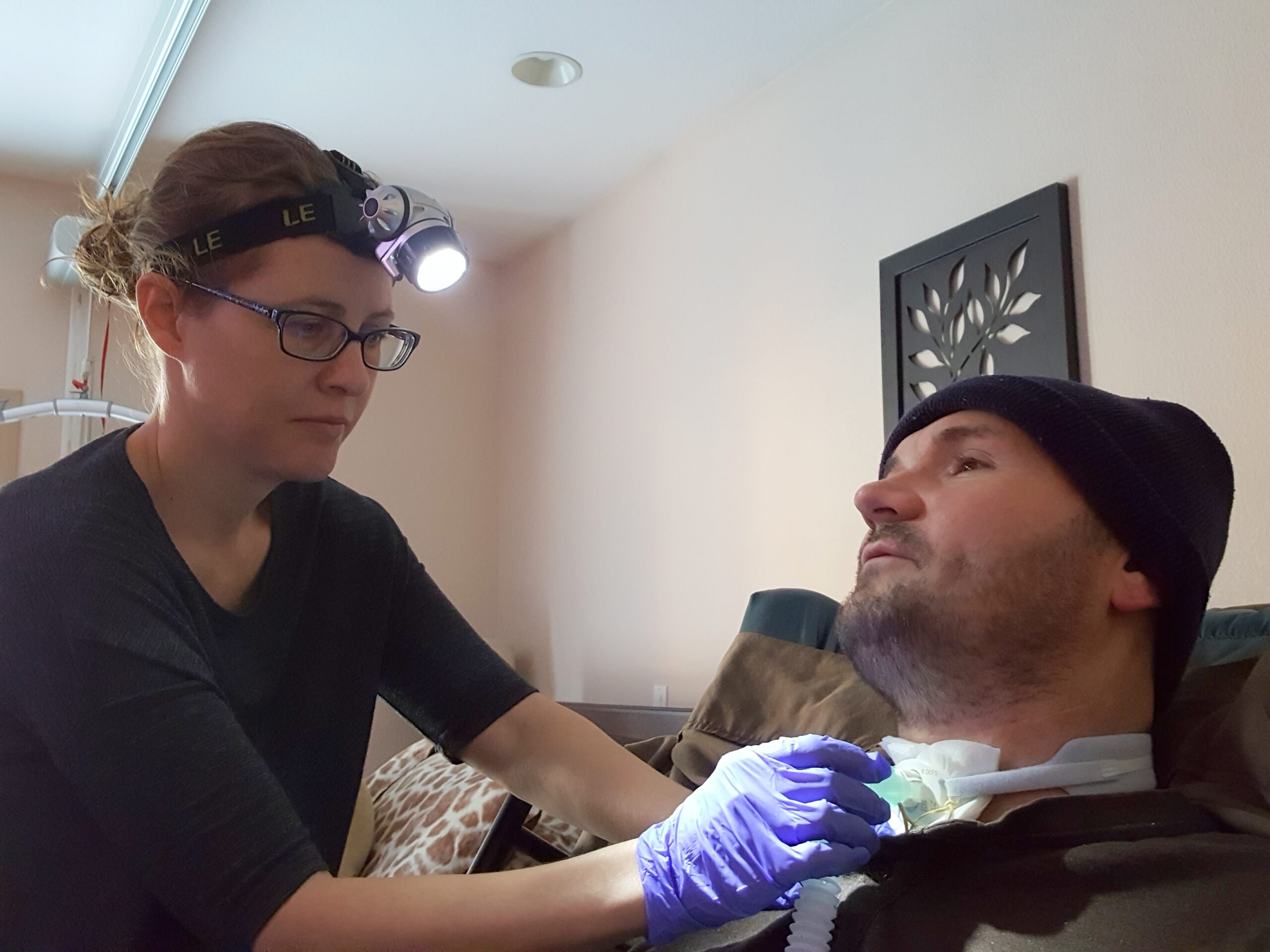 Caregiver uses a headlamp to light the works she performs on her husband