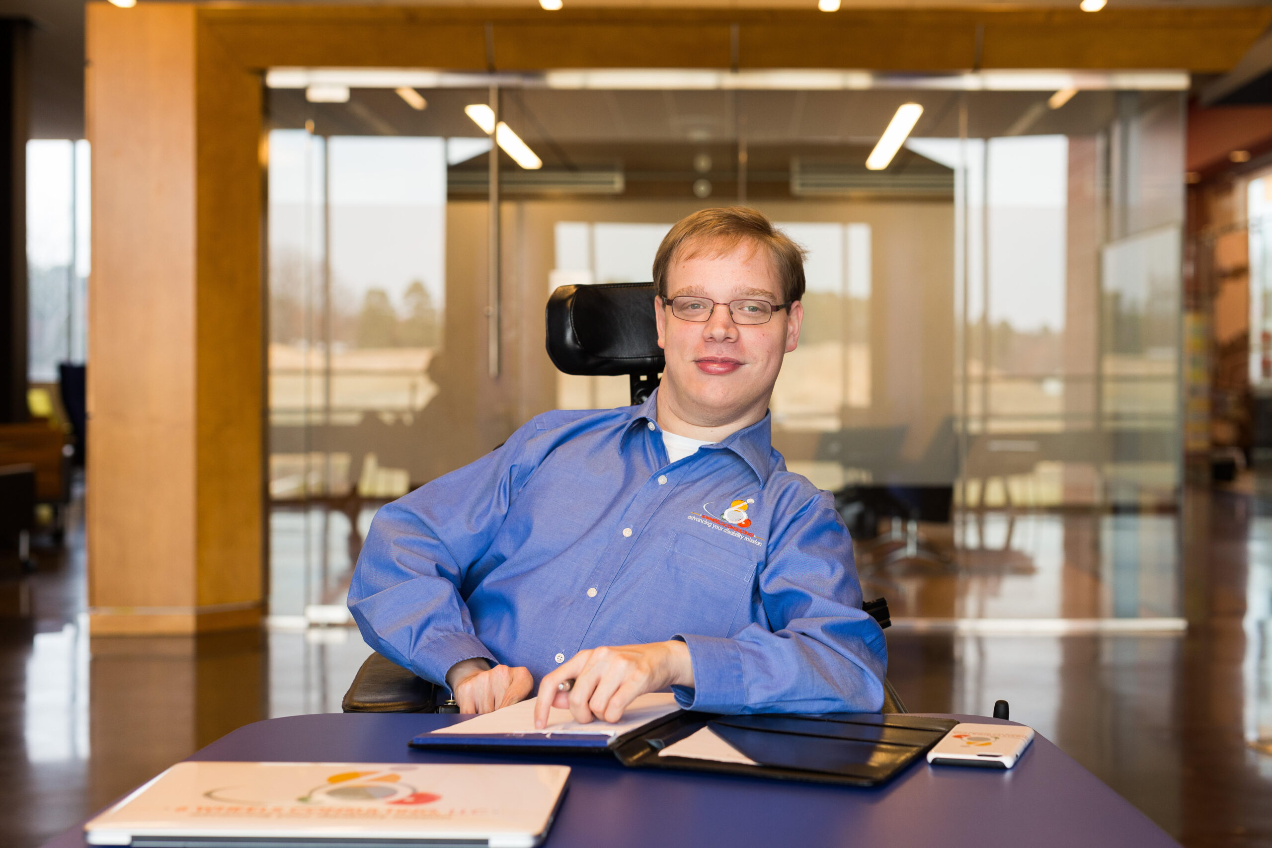 man with cerebral palsy sits at a desk