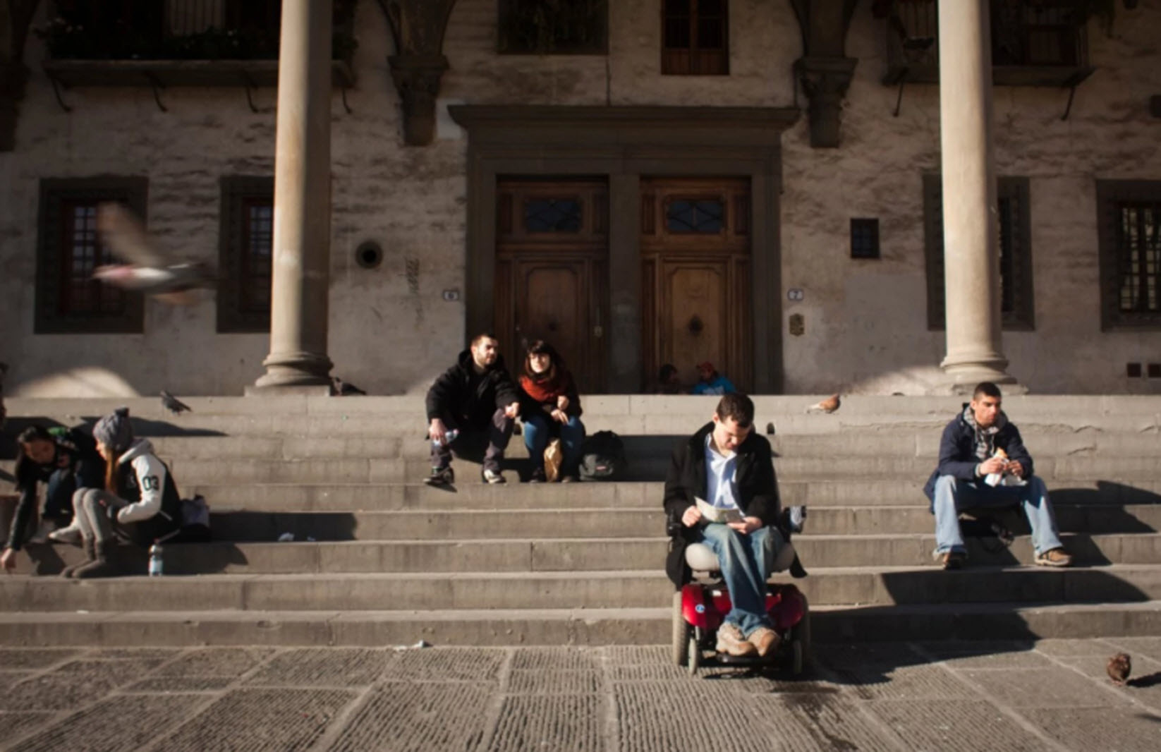 wheelchair user reads a book in Florence, Italy