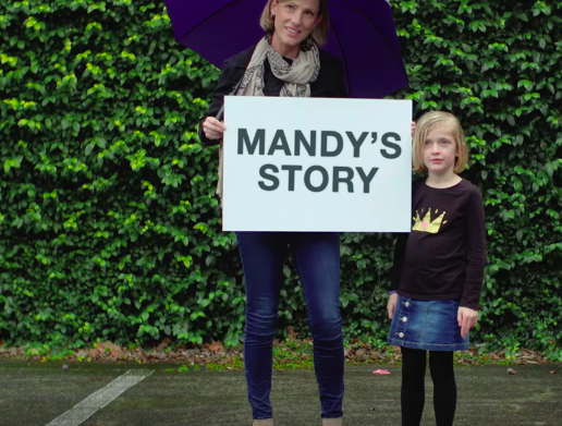 Mandy with her daughter holding up a sign that says mandy's story