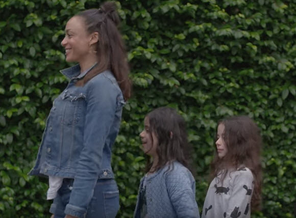 two sisters follow behind their mother