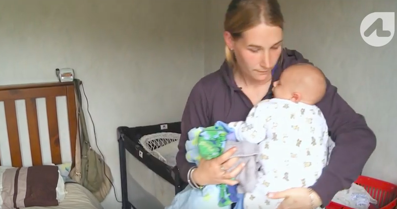 screenshot of AJ holding baby Eli