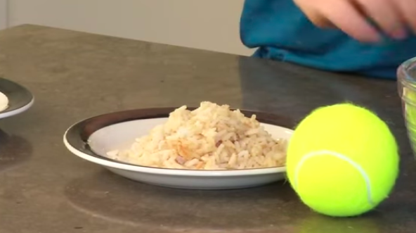 Picture of plate of grains sitting next to tennis ball