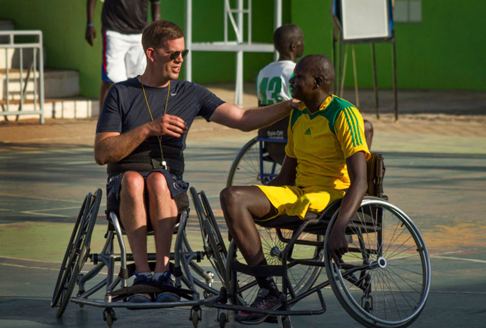 wheelchair basketball coach talks to a team member
