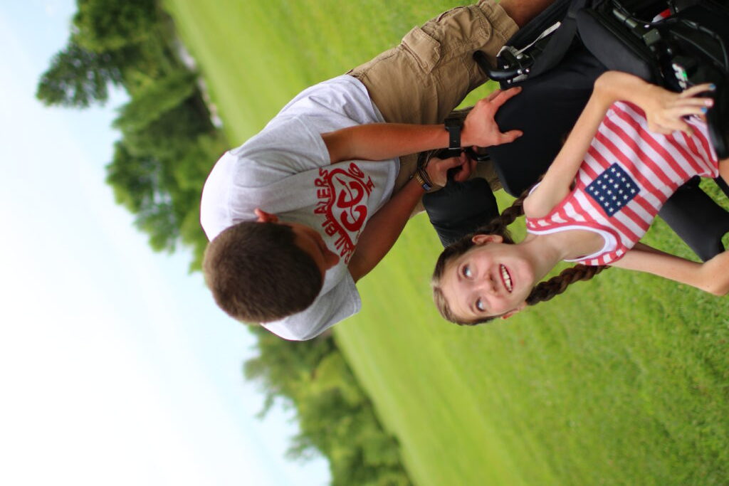 Trenton standing over Lindsay, while they look at each other. Lindsay is smiling.