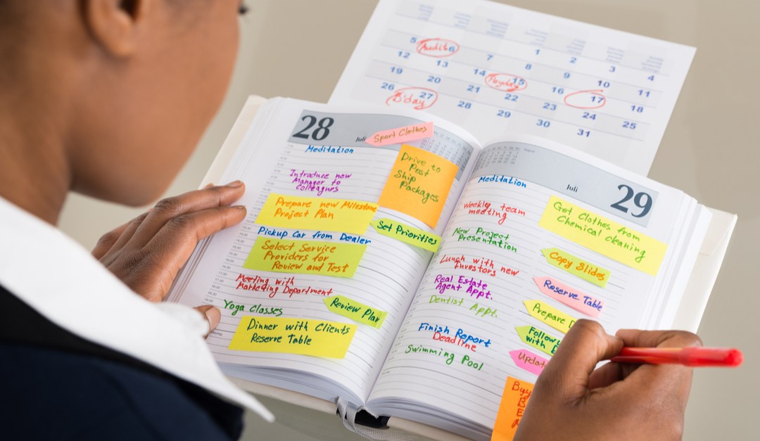 Picture of someone preparing a schedule with things written in different colors and highlighted