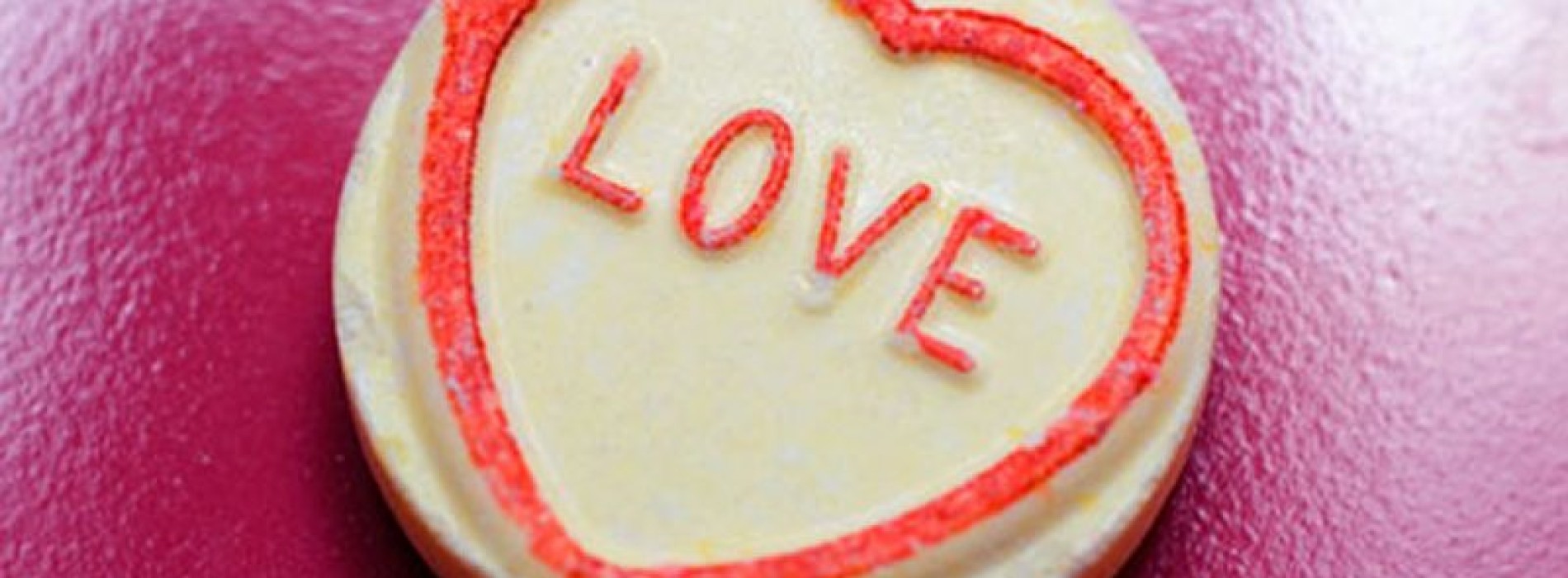 Close-up of a cookie with the word Love on it in red.