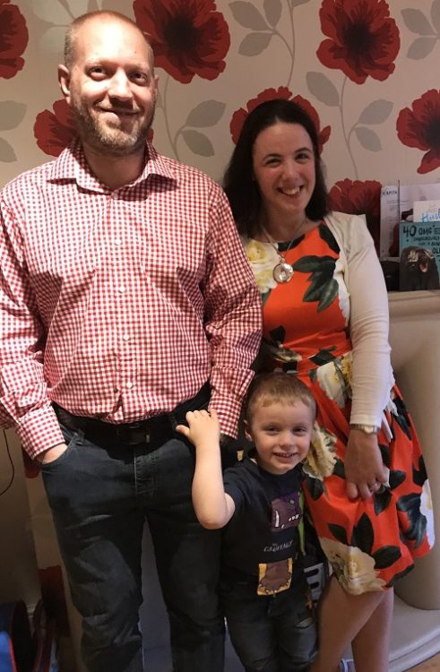 Aideen with her son and husband. They are all standing and smiling.