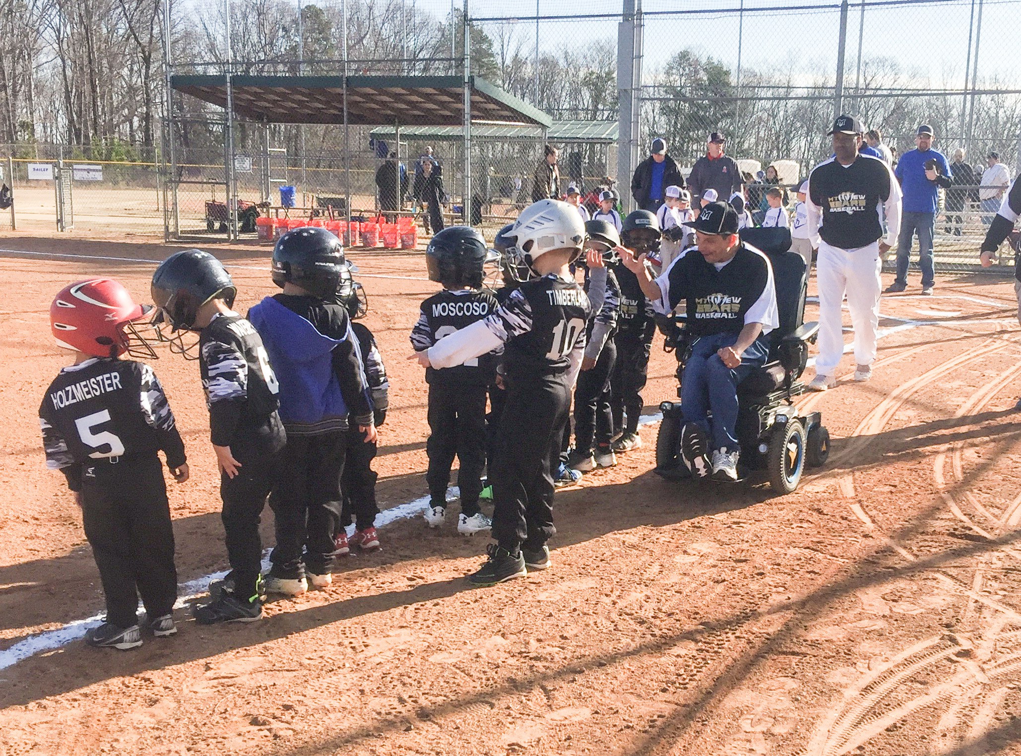 Glenn giving players high fives as they line up with helmets on